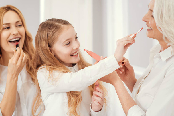 Pretty ladies of different age applying lips makeup together - Φωτογραφία, εικόνα