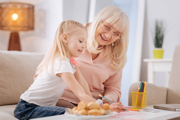 Happy positive woman spending time with her granddaughter - Photo, image