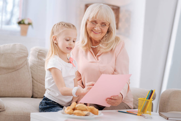 Cheerful aged woman talking to her granddaughter - Photo, image