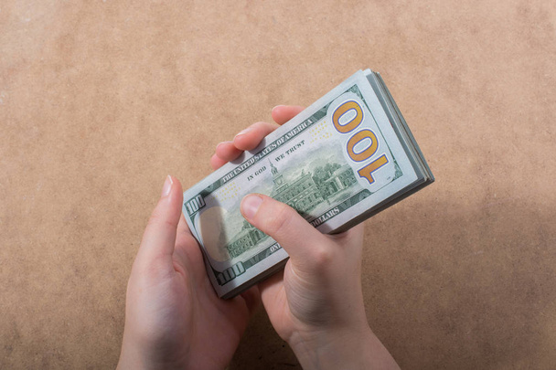 Руки з американськими доларами ізольовані на дерев'яному фоні. - Фото, зображення