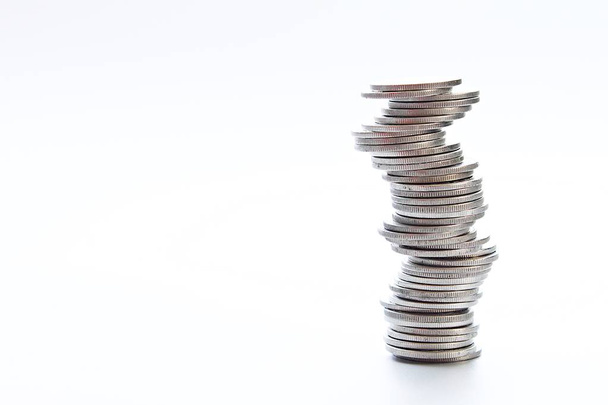 Wirtschaft, Finanzen, Sparen oder Anlagerisiko-Konzept: Münzen stapeln sich in unterschiedlichen Positionen auf weißem Hintergrund - Foto, Bild