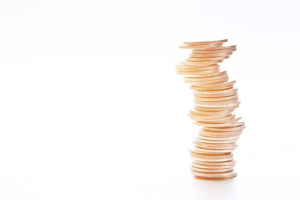 Wirtschaft, Finanzen, Sparen oder Anlagerisiko-Konzept: Münzen stapeln sich in unterschiedlichen Positionen auf weißem Hintergrund - Foto, Bild