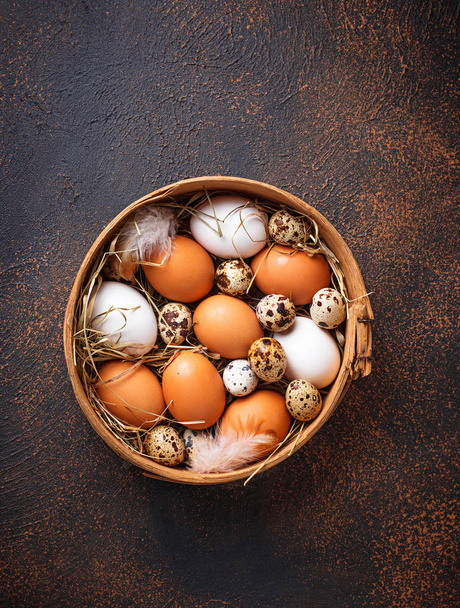 Свіжа сира курка і перепелині яйця в ситі
 - Фото, зображення