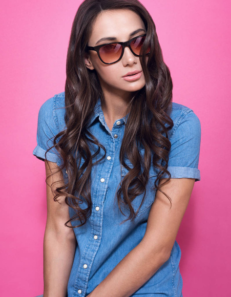 Stylish young woman in sunglasses and a blue denim shirt - Photo, image