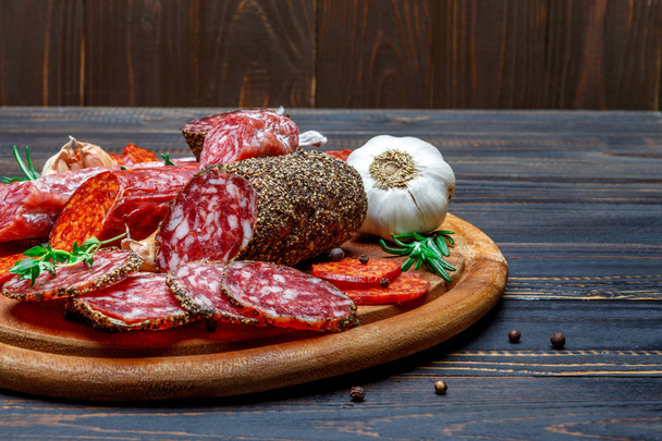 Various types of Dried organic salami sausage on wooden cutting board - Foto, Bild
