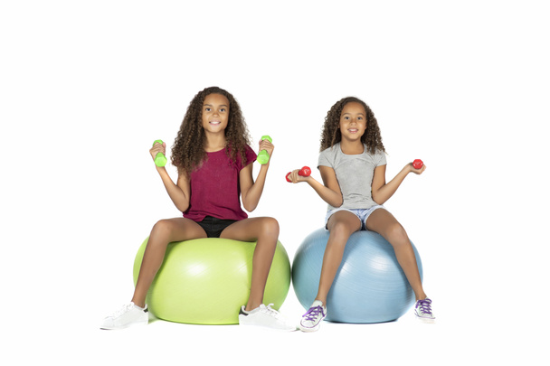 遊び心のある子供または茶色の毛再生や小さなダンベル大きいゴム製ボールに運動前十代の白人少女 - 写真・画像