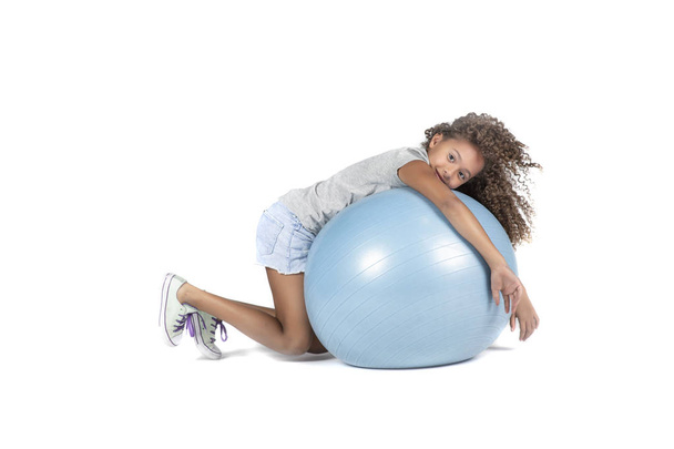 Hravé dítě nebo Pre biracial dívenky s hnědé kudrnaté vlasy, hraní nebo cvičení na velkém gumový míček - Fotografie, Obrázek
