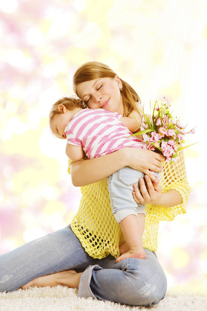 Μητέρα και το μωρό δίνει δώρο ανθοδεσμών λουλουδιών, ευτυχισμένη μαμά Αγκαλιάζοντας παιδί κορίτσι - Φωτογραφία, εικόνα