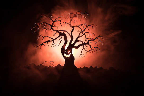 Karanlık sisli yüzündeki korku korkunç Cadılar Bayramı ağacıyla silüeti arka plan arka yüzü aya ile tonda. Zombi ve şeytan yüzü olan korkunç korku ağaç. - Fotoğraf, Görsel