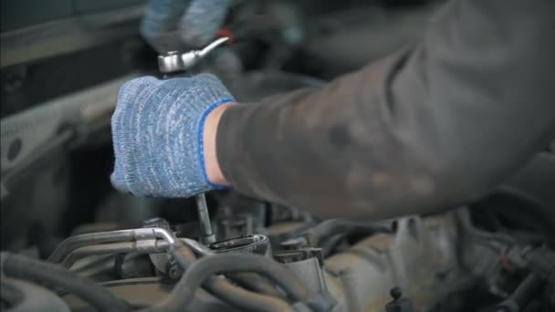 Mecánico en guantes con llave desmontar el coche
 - Metraje, vídeo