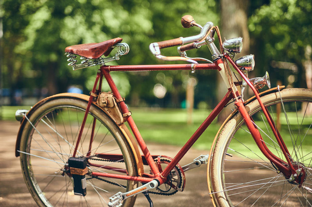 Szczelnie-do góry obraz czerwony rower vintage w parku miejskim. - Zdjęcie, obraz