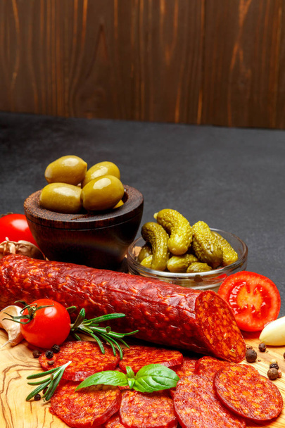 Dried organic salami sausage or chorizo on wooden cutting board - Foto, Imagem
