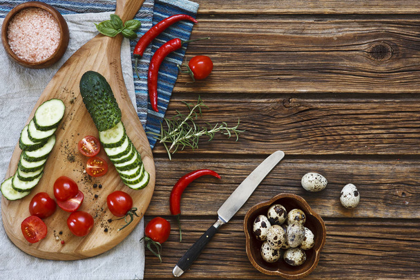 Close-up photo of fresh vegetables on wooden cutting board with knife on vintage wooden background - Zdjęcie, obraz