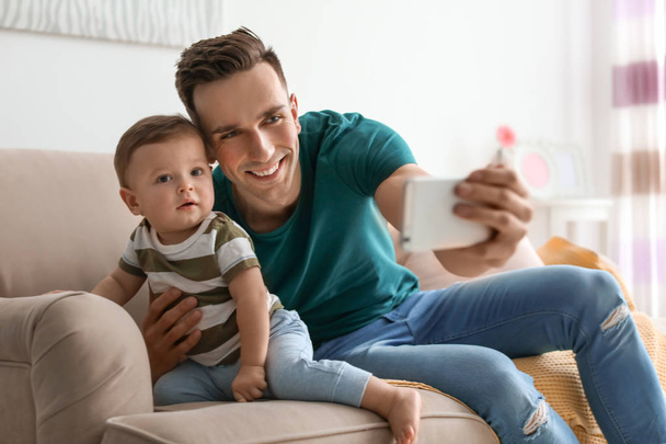 Young father with his cute little son taking selfie at home - Foto, Bild
