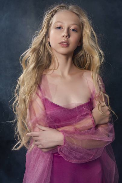 Beautiful curly blonde teenager child girl wearing a pink air dr - Foto, imagen
