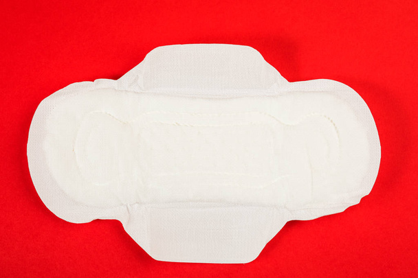 Θηλυκό γυναικείας υγιεινής των προϊόντων. Ταμπόν λευκό σε κόκκινο φόντο - Φωτογραφία, εικόνα