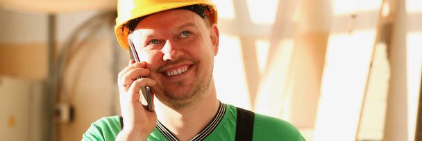 Плотник разговаривает по телефону в хозяйственном магазине - Фото, изображение