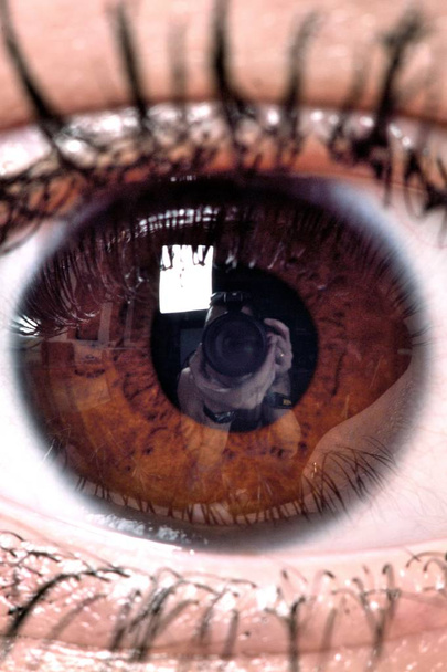 Női nyitott barna szem a reflexió a tanuló a kamera és a fotós - Fotó, kép