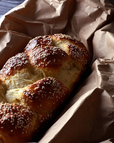 Kaunis arabialainen, itämainen leipä seesamin kanssa. Leipä tummilla sävyillä on käsityöpaperilla. Ruokahalua aamiaisen, lounaan, päivällisen lisäksi. Kotitekoinen leipä paahtoleivälle ja voileiville
. - Valokuva, kuva