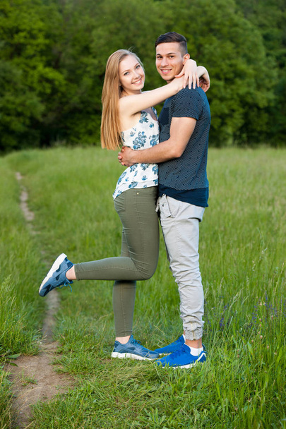 Active young couple having fun in park on hot summer agetrnoon - Foto, afbeelding