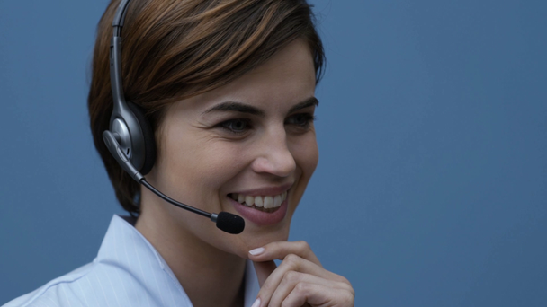 Uśmiechający się operator centrum młodych wywołania noszenie zestawu słuchawkowego i posiadające połączenie telefoniczne z klientem - Materiał filmowy, wideo