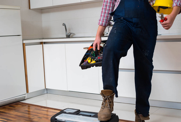Handyman de pé na cozinha com caixa de ferramentas
 - Foto, Imagem