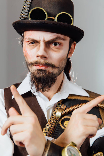 Portrait of steampunk vintage man with various mechanical devices on body. - Foto, afbeelding