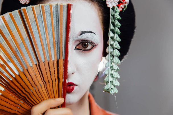 Woman in geisha makeup and a traditional Japanese kimono. Studio, Indoor. - Foto, imagen
