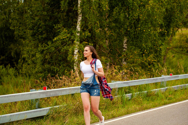 Young beautiful brown haired woman in blue jeans  - Foto, afbeelding
