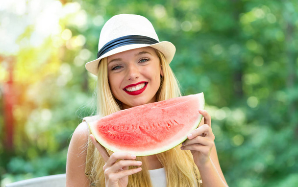 Young woman eating watermelon outside - Fotoğraf, Görsel