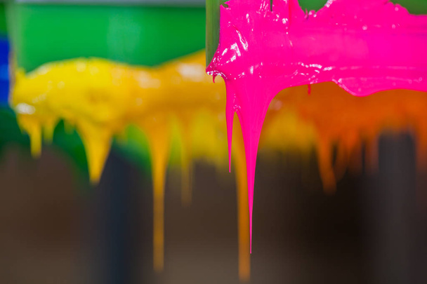 colorido de palo de tinta de plastisol en el mango de la impresora empezar a fluir hacia abajo
  - Foto, Imagen