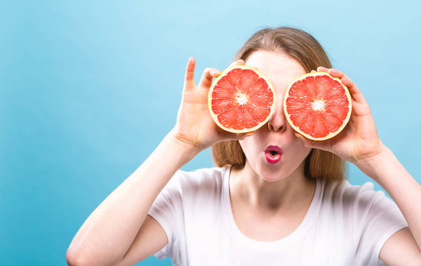 Счастливая молодая женщина с грейпфрутами
 - Фото, изображение