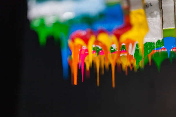 kleurrijke van plastisol inkt stick op printer handvat start stroomt naar beneden  - Foto, afbeelding