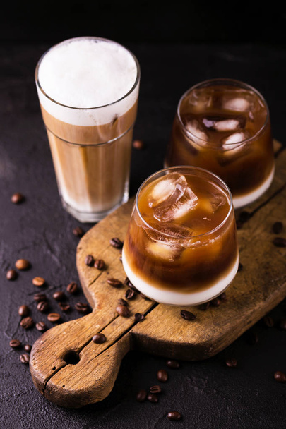 Iced coffee in glasses with milk. Black background - Фото, изображение