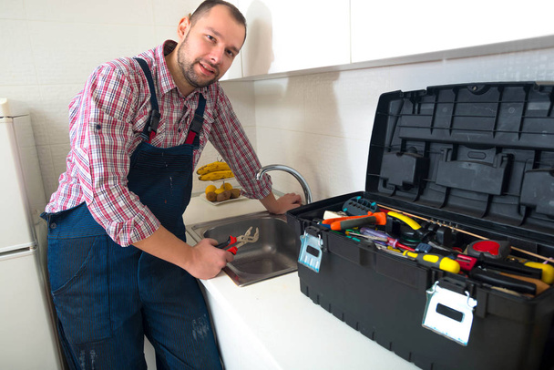 Beau homme debout dans la cuisine avec sa boîte à outils
 - Photo, image