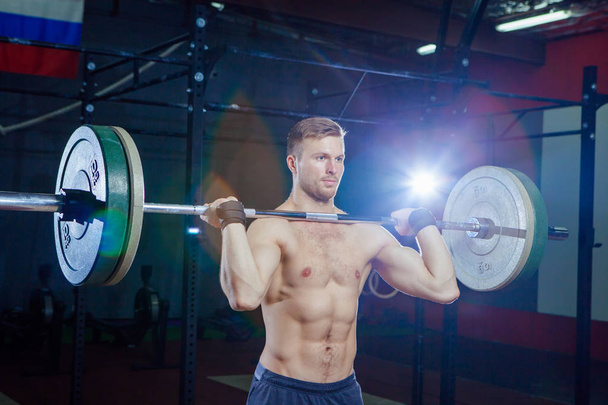 Muscular fitness man preparing to deadlift a barbell over his head in modern fitness center.Functional training.Snatch exercise. Cross fit style, deadlift - Foto, Imagem