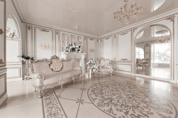 Lujoso interior vintage con chimenea en el estilo aristocrático. Ventanas grandes y espejos. Columnas y arcos, adorno en el suelo brillante
 - Foto, imagen