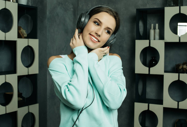 Young beautiful woman in casual outfit enjoying the music at home - Foto, Imagen