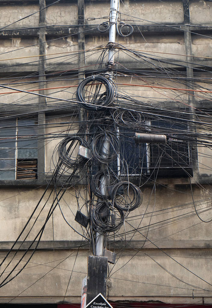 das Chaos von Kabeln und Leitungen in Kolkata. Glasfasertechnologie unter freiem Himmel in asiatischen Städten entdeckt. - Foto, Bild