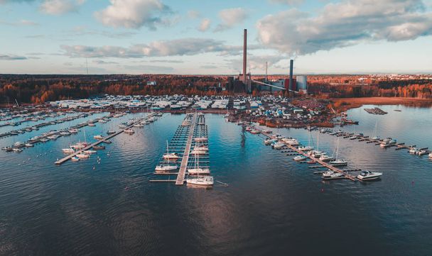 Marina de Suomenoja com barcos no cais e na costa na cegonha e nas costas Usina de Suomenoja
 - Foto, Imagem