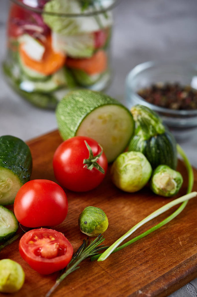 Friss növényi saláta és érett zöldségeket a daraboló board át a fehér háttér, közelkép, szelektív összpontosít - Fotó, kép