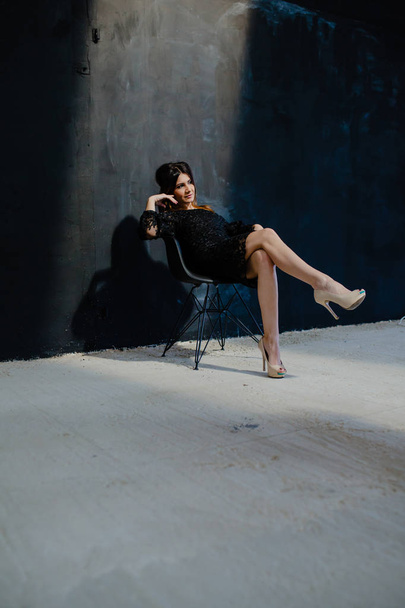 Brunette posing near black wall in the studio - Foto, imagen