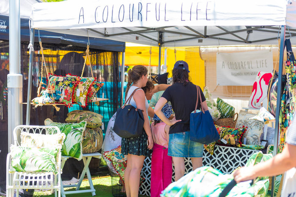 People shopping at festival stall on outdoor fair in Byron Bay, NSW, Australia - Fotó, kép