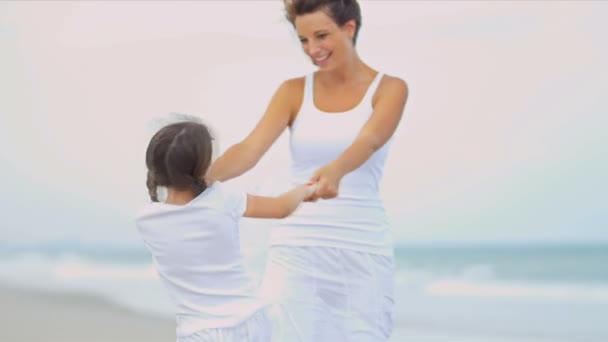 Caucasian girl enjoying beach dancing with mother - Footage, Video