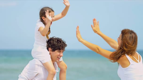 Caucásico padres jugando hija siendo llevado en padres hombros en playa
 - Metraje, vídeo