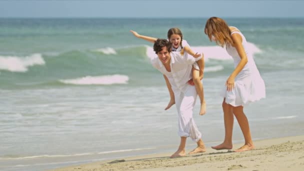 Kaukasische Eltern Tochter genießt Zeit zusammen zu Fuß am Strand - Filmmaterial, Video