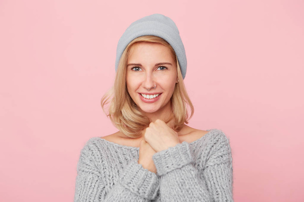 Portrait of charming glad woman keep hands under chin, feel happiness and recieves a flat of her dreams. Isolated over pink background - Photo, Image