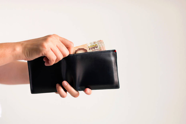 Τα χέρια να πάρει χρήματα σε Ταϊλανδικό μπατ από το πορτοφόλι για την πληρωμή. - Φωτογραφία, εικόνα