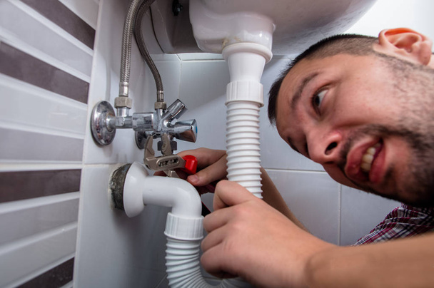 Υδραυλικός, τον καθορισμό ενός νεροχύτη στο μπάνιο με γαλλικό κλειδί - Φωτογραφία, εικόνα
