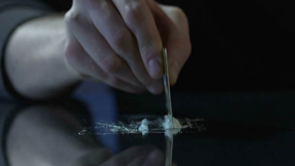 Wykonanie linii kokainy przez kartę z pakietami narkotyków na stole, uzależnienie od handlarza narkotyków - Materiał filmowy, wideo